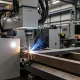 Professional operating laser welding machine with proper safety equipment in Canadian manufacturing facility