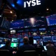 Professional macro trader analyzing stock market today data on multiple monitors with real-time charts