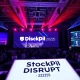 StockPil Disrupt 2025 conference attendees networking at Moscone West with tech displays