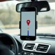 Smartphone on car dashboard showing GPS map in Allstate privacy lawsuit over driver tracking.