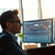 Financial analyst reviewing bond market data and ETF performance charts on computer monitors.