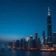 China economic growth forecast showing Shanghai financial district skyline at dusk representing economic analysis