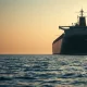 Oil tanker in the Strait of Hormuz as crude prices surge on geopolitical news.