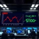 Stock market ticker showing Dow Jones decline and crude oil price surge past $100 a barrel.