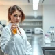 Research scientist in Esperion Therapeutics laboratory analyzing cardiovascular drug sample for earnings report context.