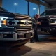 Ford F-150 and Bronco at service center for critical headlight and engine valve recall inspection.