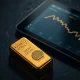 Gold bullion bar with a financial chart showing a price decline ahead of the Federal Reserve meeting.