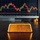 Gold bullion bar with financial charts showing market vulnerability amid geopolitical tensions and Federal Reserve policy uncertainty