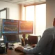 Financial trading desk with monitors showing stock charts and market data