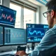 Financial analyst reviewing XRP cryptocurrency price charts on multiple monitors in office setting.