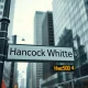 Hancock Whitney financial district sign with stock ticker showing HWC price during oversold RSI alert