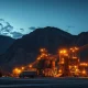 Industrial gold mining operation at dusk, representing the metals and mining sector.