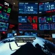 Trading floor monitors show market reaction to the historic IEA oil reserve release announcement on March 11, 2026.