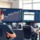 Financial analyst reviews iShares U.S. Thematic Rotation Active ETF (THRO) insider buying data and stock charts in a newsroom.