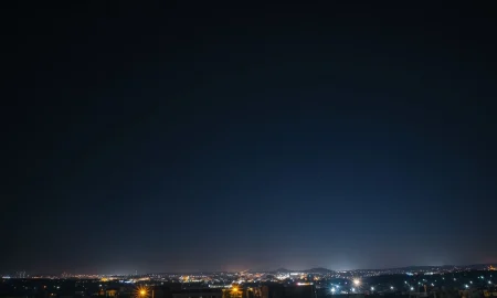 Illustration of missile defense interceptors in a night sky over an urban landscape.