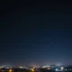Illustration of missile defense interceptors in a night sky over an urban landscape.
