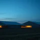 A modern hog farming facility at dusk, representing the livestock commodity market.