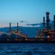 Natural gas processing facility at dusk as prices surge amid Iran conflict and Strait of Hormuz tensions in March 2026.