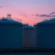 Natural gas storage tanks at an industrial facility during twilight.