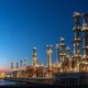 Natural gas processing facility at dusk as prices surge amid Strait of Hormuz tensions in March 2026