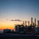 Natural gas processing facility at dusk illustrating global energy supply chain amid Iran conflict market volatility
