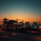 Damaged LNG export terminal at Ras Laffan after reported Iranian attacks, with oil prices rising.