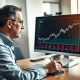Financial analyst reviews Old Republic International (ORI) stock chart and dividend report in professional office setting.