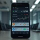 Cryptocurrency price chart analysis on a smartphone screen with exchange logos.