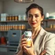 Poppi founder Allison Ellison holding a can of prebiotic soda in a beverage lab, discussing the brand's $1.95 billion acquisition.