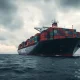 Cargo ship at sea illustrating global shipping routes affecting coffee prices.