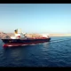 An oil tanker transits the narrow Strait of Hormuz, a key global shipping lane.