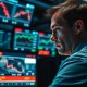 Trader monitors falling stock market charts amid Iran conflict news.