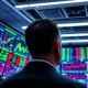 Stock market monitors showing rising indices after US-Iran diplomacy news.