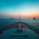 Strait of Hormuz crisis scene showing oil tanker in strategic maritime chokepoint at dawn.