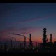 Oil refinery at dusk representing Trump's comments on Iranian oil policy.