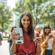 Young adults using smartphones for fashion shopping, representing VSCO's digital transformation success with Gen Z consumers.