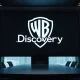 Warner Bros Discovery logo in a corporate setting with Singapore skyline.