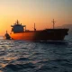 Oil tanker and naval escort in Strait of Hormuz amid WTI crude oil price volatility
