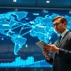 Analyst in bank operations center reviewing global transaction data on a digital map.