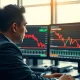 A trader monitors USD/JPY charts as the Japanese yen weakens on soft inflation data.