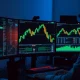 A trader's monitor displays a cryptocurrency price chart showing altcoin gains.