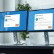 Anthropic AI agent marketplace interface showing a completed transaction on two monitors in a modern office