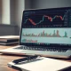 Analyst reviewing stock charts for business services companies on a laptop screen.