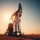 Oil drilling rig at sunset representing Chevron and Exxon's core business.