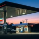 A Chevron gas station at dusk, representing the energy company's stock price target increase.