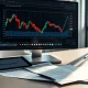 Financial analyst's desk with a stock chart showing a Groupon price target revision.
