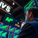 Trader monitors stock charts as S&P 500 and Nasdaq 100 hit record highs.