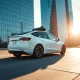 A Tesla vehicle driving autonomously on a city street with an empty driver's seat.