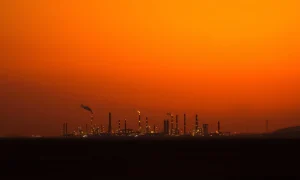 An oil refinery at dusk as WTI crude prices hold near $89 amid Middle East tensions.