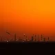An oil refinery at dusk as WTI crude prices hold near $89 amid Middle East tensions.